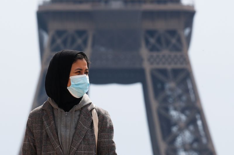 &copy; Reuters. امرأة ترتدي حجابا وتضع كمامة للوقاية من فيروس كورونا عند برج إيفل في العاصمة الفرنسية باريس يوم الاثنين. تصوير: جونسالو فوينتس - رويترز.