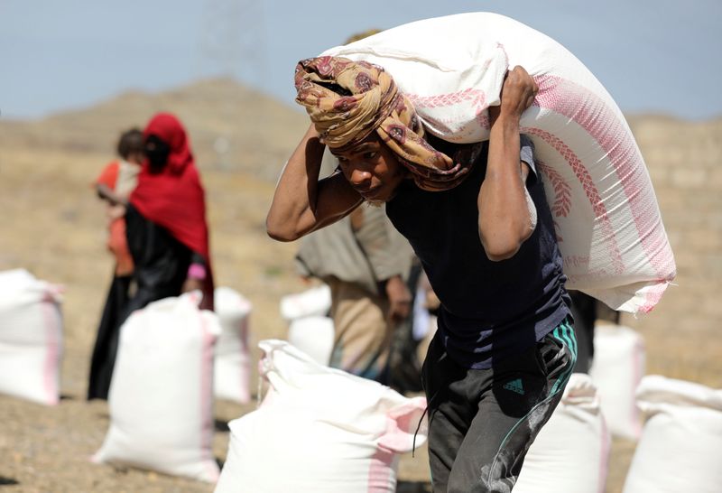&copy; Reuters. عامل ينقل أجولة دقيق مقدمة من إحدى منظمات الإغاثة في مخيم للنازحين على أطراف صنعاء يوم 1 مارس آذار 2021. رويترز