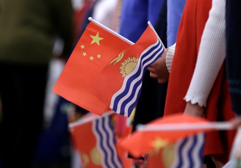 &copy; Reuters. FILE PHOTO: Students holding national flags of China and Kiribati wait for a welcoming ceremony  for Kiribati's President Taneti Maamau at the Great Hall of the People in Beijing, China January 6, 2020. REUTERS/Jason Lee