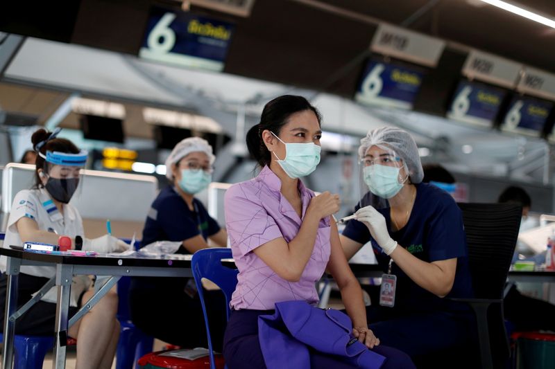 &copy; Reuters. タイ中央銀行は５日、政策金利を過去最低の０．５０％に据え置いた。バンコクのスワンナプーム国際空港でコロナワクチンを接種する客室乗務員、４月２８日撮影。（２０２１年　ロイタ