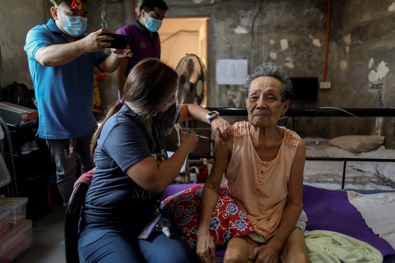 &copy; Reuters. Ederlina Paraiso, 81, gets a shot of China's Sinovac coronavirus disease (COVID-19) vaccine at home, administered by health workers at Marikina, Metro Manila, Philippines, May 5, 2021. REUTERS/Eloisa Lopez