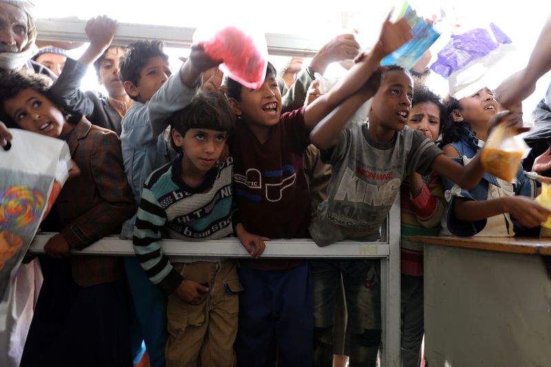 &copy; Reuters. أشخاص يتجمعون للحصول على حصص غذائية من أحد المطابخ الخيرية في صنعاء بصورة من أرشيف رويترز.