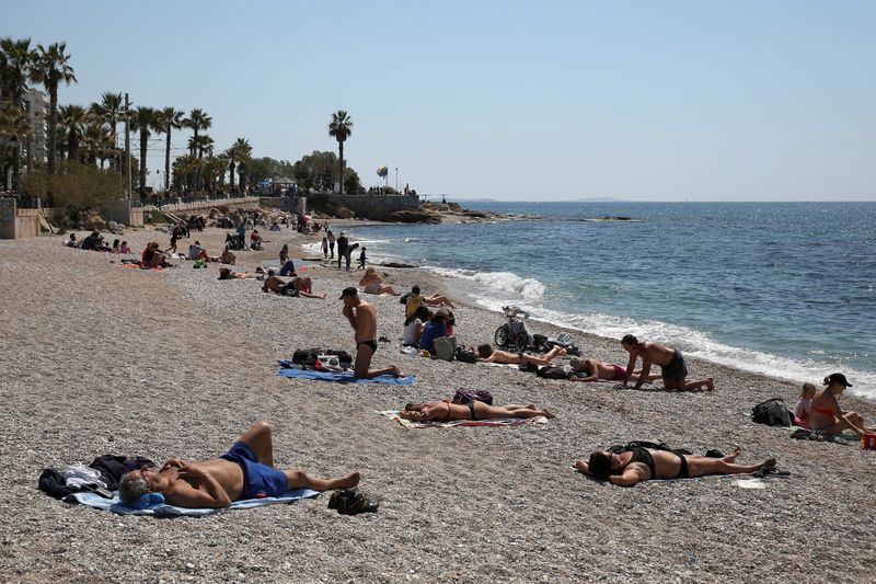 &copy; Reuters. FOTO DE ARCHIVO: Varias personas toman el sol en una playa tras la relajación de restricciones por la COVID-19 en el área de Faliro, cerca de Atenas, Grecia, el 3 de abril de 2021. REUTERS/Costas Baltas