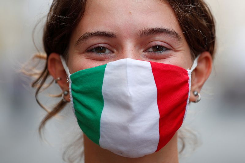 &copy; Reuters. Una donna indossa una maschera con i colori della bandiera italiana in Via del Corso, a Roma, Italia, 21 settembre , 2020. REUTERS / Guglielmo Mangiapane