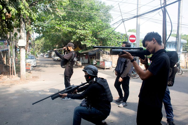 © Reuters. FILE PHOTO: Protesters hold homemade pipe air guns during a protest against the military coup in Yangon