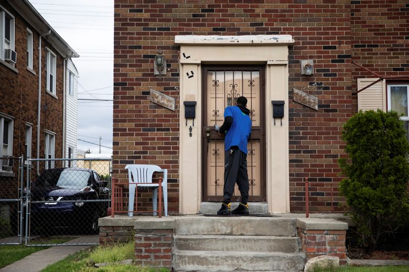 © Reuters. Sirgregory Allen from Better Men Outreach knocks on a door during a door-knock campaign to help answer questions related to hesitancy around the coronavirus disease (COVID-19) vaccine in Detroit, Michigan, U.S., May 4, 2021. REUTERS/Emily Elconin 