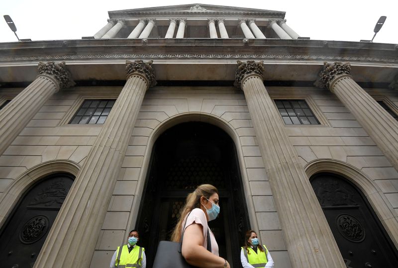 &copy; Reuters. FILE PHOTO: A worker wearing a protective face mask walks past the Bank of England in the City of London, Britain, August 6, 2020. REUTERS/Toby Melville
