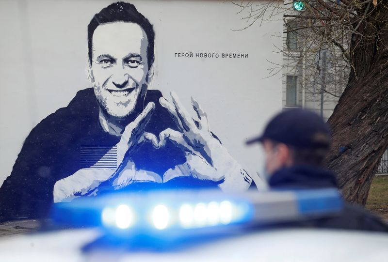 &copy; Reuters. FILE PHOTO: A police officer stands next to a car in front of a graffiti depicting Alexei Navalny in Saint Petersburg