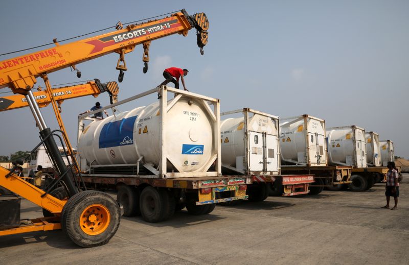© Reuters. FILE PHOTO: Men park Linde tankers after they arrived from abroad to help with coronavirus disease (COVID-19) crisis, at Netaji Subhas Chandra Bose International Airport (NSCBIA) in Kolkata, India, May 2, 2021. REUTERS/Rupak De Chowdhuri