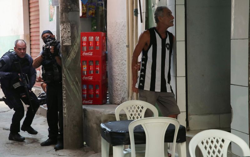 © Reuters. شرطيان خلال عملية أمنية ضد عصابات مخدرات في ريو دي جانيرو يوم الخميس. تصوير: ريكاردو مورايس - رويترز. 