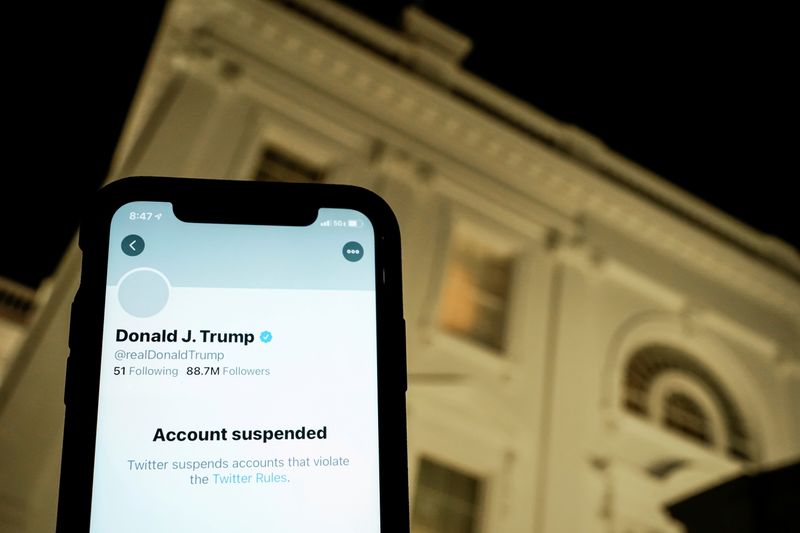 &copy; Reuters. FILE PHOTO: A photo illustration shows the suspended Twitter account of U.S. President Donald Trump on a smartphone and a lit window in the White House residence in Washington