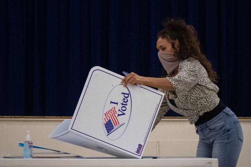 © Reuters. FILE PHOTO: Presidio County election judge Lauren Martinez folds a booth after polls and voting ended for the 2020 U.S. presidential election in Marfa, Texas, U.S., November 3, 2020. REUTERS/Adrees Latif