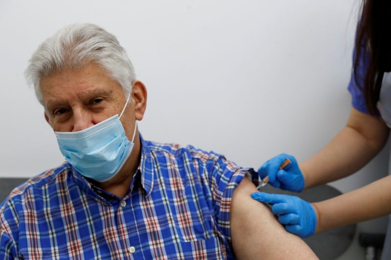 &copy; Reuters. رجل يحصل على تطعيم ضد كوفيد-19 في لندن يوم 14 يناير كانون الثاني 2021. تصوير: بول تشايلدز - رويترز. 