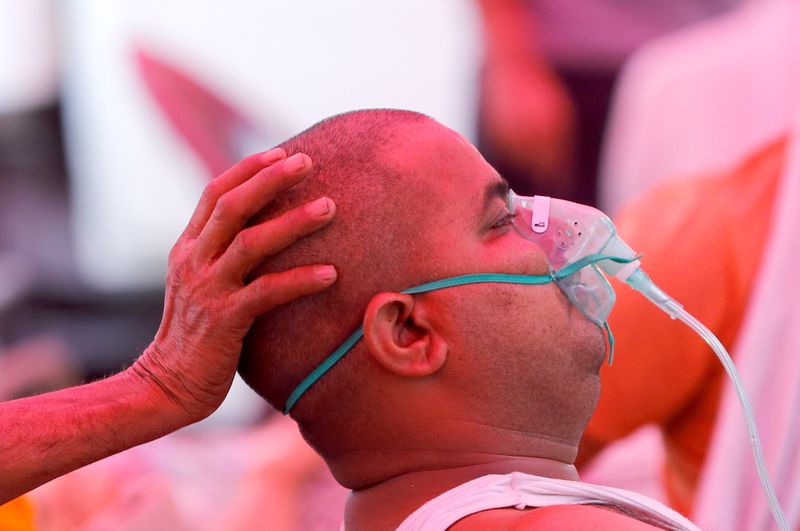&copy; Reuters. رجل يعاني من مشكلة في التنفس يحصل على أكسجين في غازي أباد بالهند يوم الثالث من مايو ايار 2021. تصوير: عدنان عبيدي - رويترز. 
