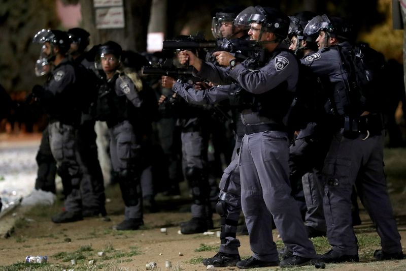 © Reuters. أفراد من الشرطة الإسرائيلية يوجهون أسلحتهم خلال اشتباكات مع فلسطينيين في القدس يوم الجمعة. تصوير: عمار عوض - رويترز. 