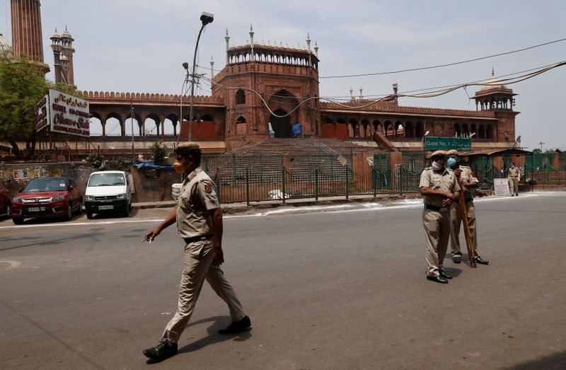 &copy; Reuters. Policemen stand in front of Jama Masjid or Grand Mosque on Jumat-ul-Vida or the last Friday of the holy fasting month of Ramadan, in the old quarters of Delhi