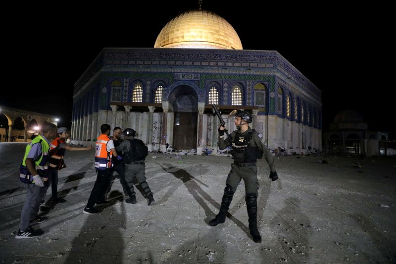 &copy; Reuters. مشاجرة بين أحد أفراد الشرطة الإسرائيلية وفلسطيني أمام قبة الصخرة أثناء اشتباكات عند المسجد الأقصى في القدس في ساعة متأخرة من مساء الجمعة. ت