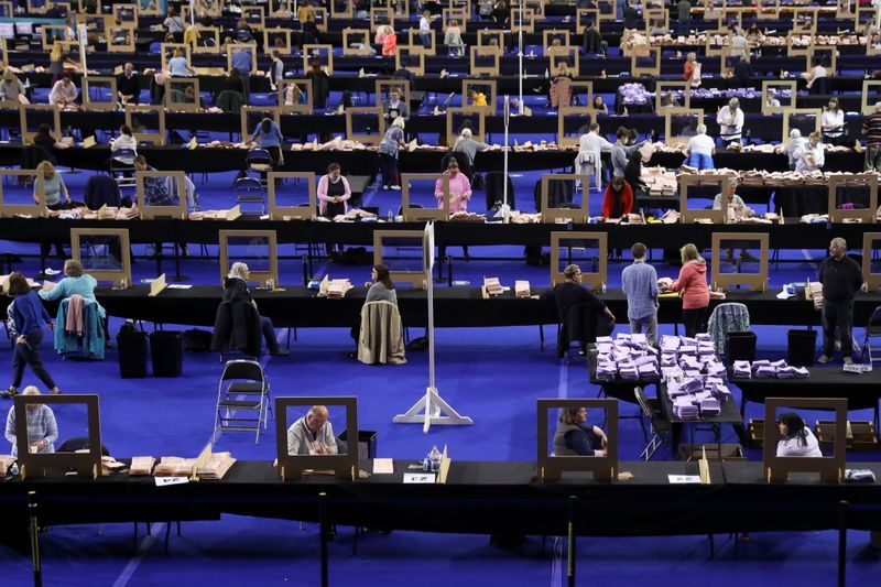 © Reuters. أفراد من لجنة الانتخابات البرلمانية في اسكتلندا أثناء عد الاصوات في جلاسجو يوم السبت. تصوير: رويترز.