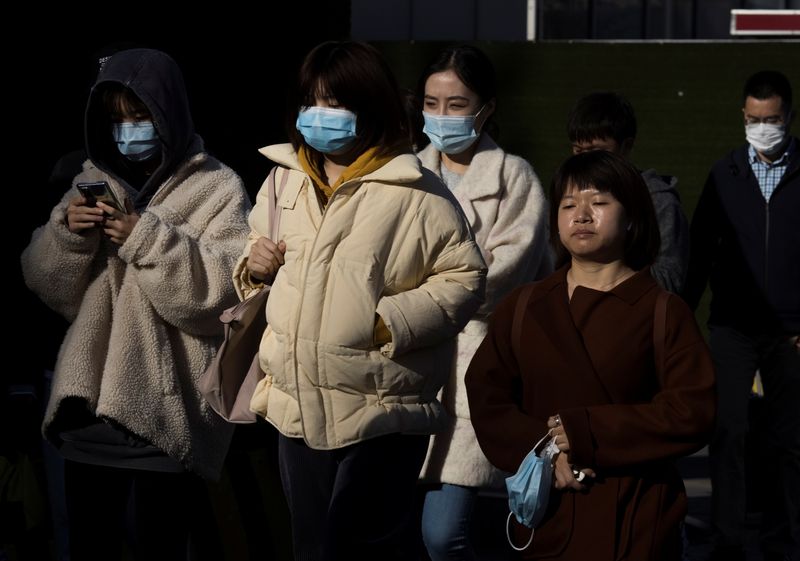 &copy; Reuters. FILE PHOTO: People walk in a street during morning rush hour following an outbreak of the coronavirus disease (COVID-19) in Beijing