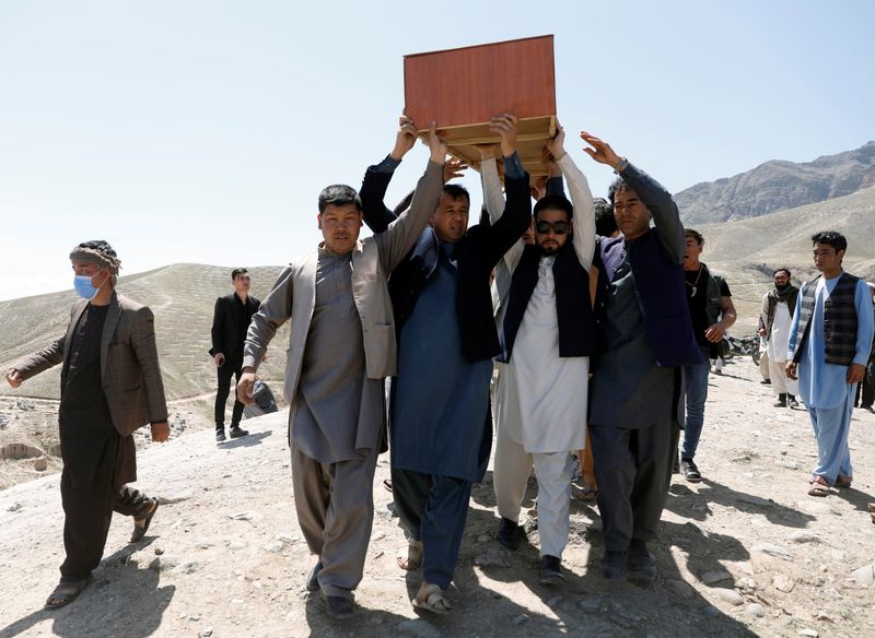 © Reuters. رجال أفغان يحملون جثمان أحد ضحايا انفجار مدرسة في كابول لدفنه يوم الاحد. تصوير رويترز. 