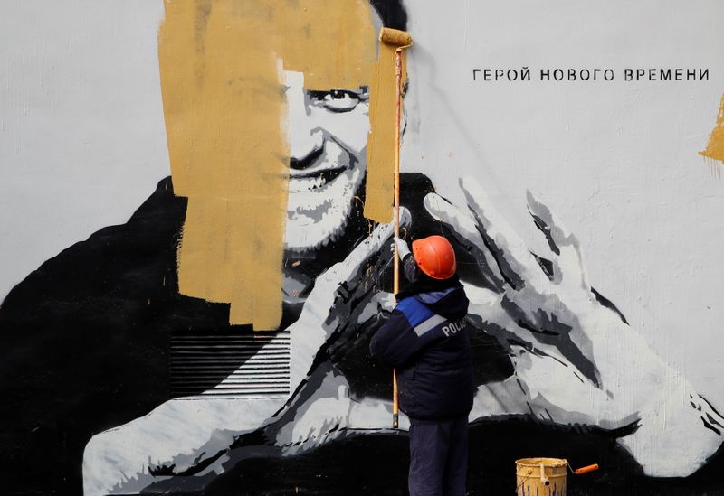&copy; Reuters. A worker paints over a graffiti depicting jailed Russian opposition politician Alexei Navalny in Saint Petersburg, Russia April 28, 2021. The graffiti reads: "The hero of the new age". REUTERS/Anton Vaganov - RC2V4N9QE6MC