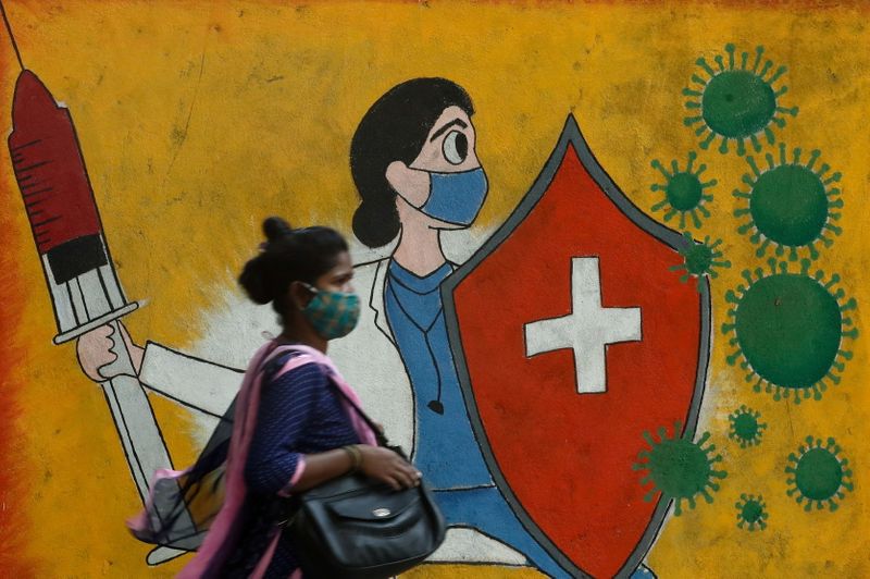 &copy; Reuters. A woman walks past a graffiti on a street, amidst the spread of the coronavirus disease (COVID-19) in Mumbai, India, May 10, 2021. REUTERS/Francis Mascarenhas