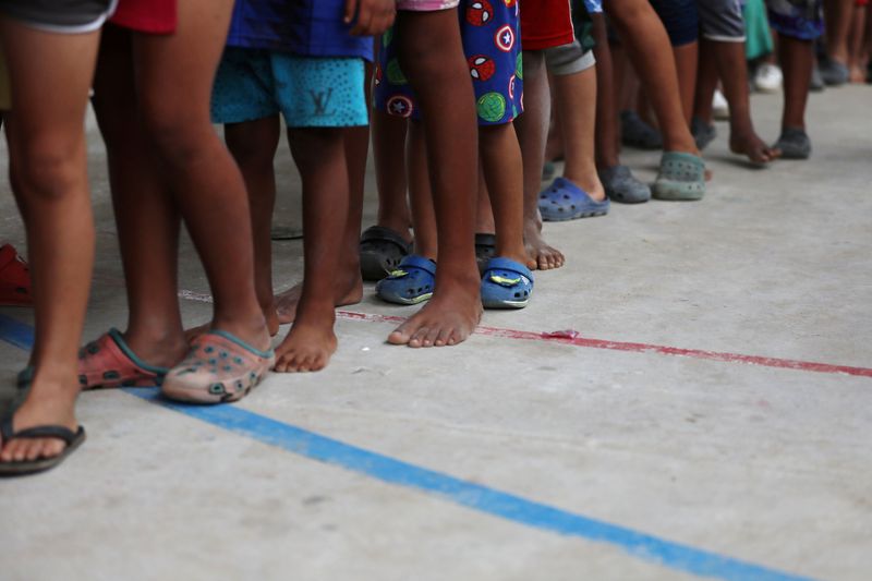 &copy; Reuters. FOTO DE ARCHIVO. Niños inmigrantes venezolanos hacen fila dentro de un coliseo adaptado como centro de refugio temporal en  Arauquita, Colombia. Marzo, 2021. REUTERS/Luisa Gonzalez   