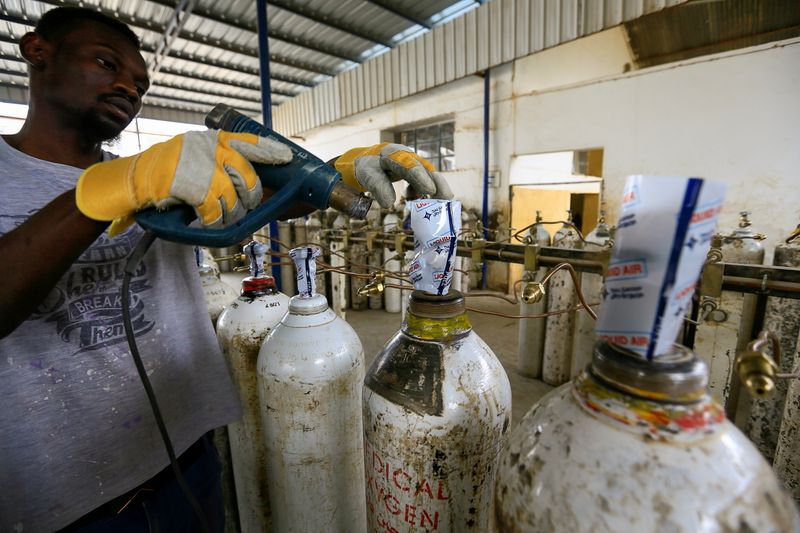 &copy; Reuters. عامل يجهز اسطوانات أكسجين في مصنع بالخرطوم يوم الخامس من مايو ايار 2021. تصوير: محمد نور الدين عبد الله - رويترز. 