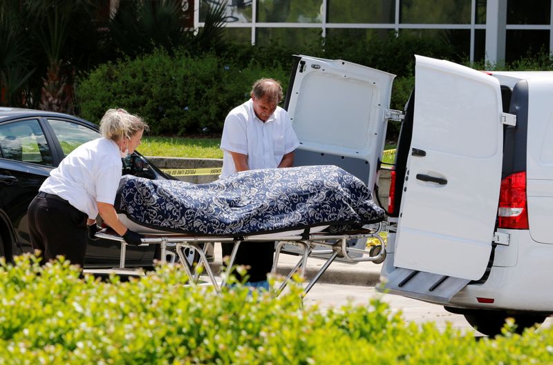 © Reuters. Officials move a body at the site of a fatal shooting outside a U.S. Customs and Immigration Service building in Orlando, Florida, U.S., May 10, 2021.  REUTERS/Joe Skipper