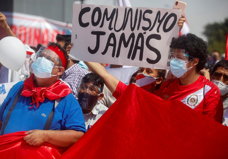 &copy; Reuters. FILE PHOTO: People hold a sign reading "Communism never" during a protest, led by former presidential candidate Rafael Lopez Aliaga (not pictured), against socialist candidate Pedro Castillo, who will face right-wing opponent Keiko Fujimori in a run-off v