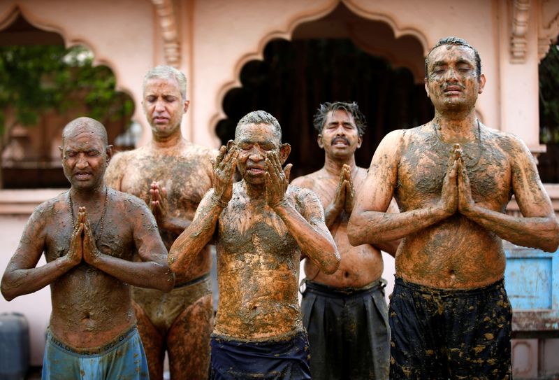&copy; Reuters. People pray after applying cow dung on their bodies during "cow dung therapy", believing it will boost their immunity to defend against the coronavirus disease (COVID-19) at the Shree Swaminarayan Gurukul Vishwavidya Pratishthanam Gaushala or cow shelter 