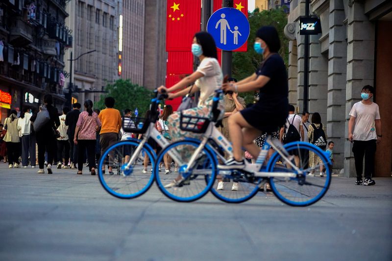 &copy; Reuters. Woman ride bikes on a street, following the outbreak of the coronavirus disease (COVID-19), in Shanghai, China May 10, 2021. REUTERS/Aly Song