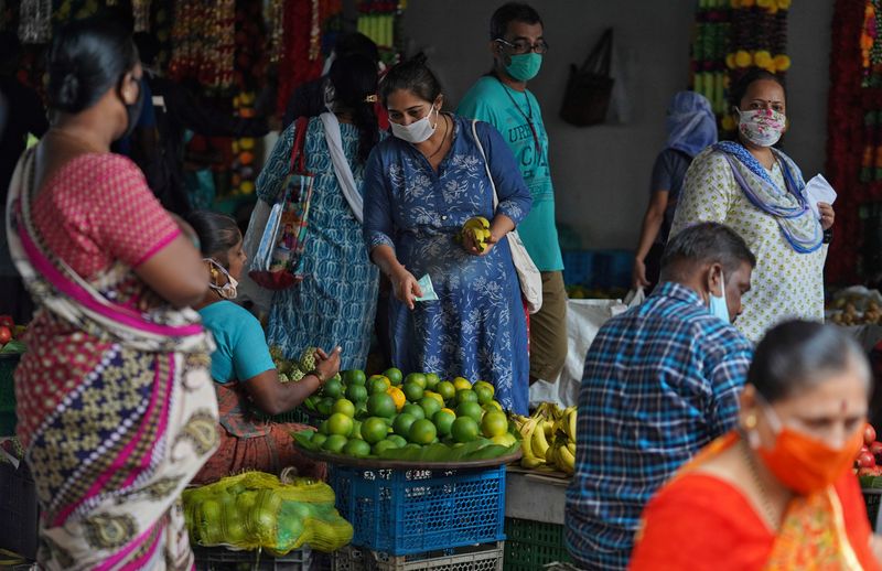 &copy; Reuters. FILE PHOTO: A woman wearing a protective face mask buys fruit in a market, amidst the spread of the coronavirus disease (COVID-19) in Mumbai, India, August 20, 2020. REUTERS/Hemanshi Kamani