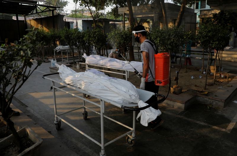 &copy; Reuters. A municipal worker sprays disinfectant on the bodies of victims who died due to the coronavirus disease (COVID-19), at a crematorium in New Delhi, India, May 10, 2021. REUTERS/Adnan Abidi