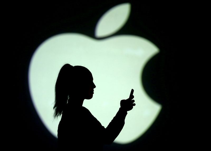 &copy; Reuters. FILE PHOTO: Silhouette of a mobile user seen next to a screen projection of the Apple logo in this picture illustration taken March 28, 2018.  REUTERS/Dado Ruvic/Illustration