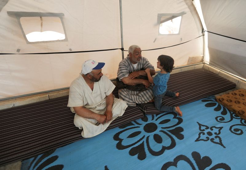 &copy; Reuters. FILE PHOTO: Youssef Ramadan, talks to his son as he sits inside a tent at Teh camp for internally displaced Syrians, in northern Idlib, Syria, May 5, 2021. REUTERS/Khalil Ashawi