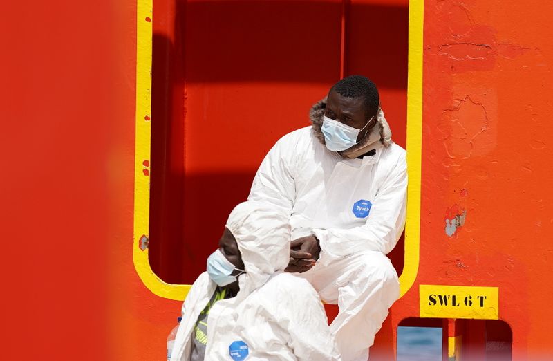 &copy; Reuters. Due migranti riposano dopo essere sbarcati a Lampedusa. 11 maggio 2021. REUTERS/Antonio Parrinello