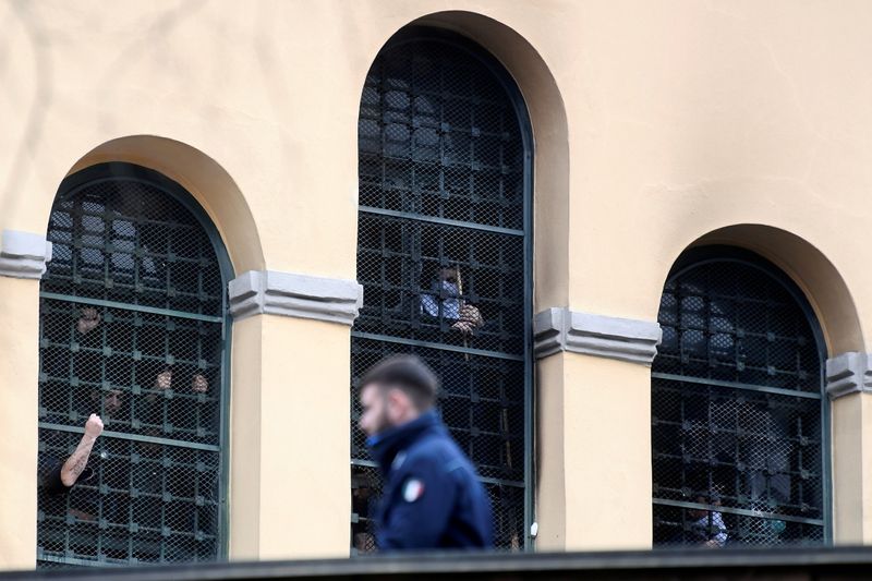 &copy; Reuters. Braccia dei detenuti si sporgono dalle finestre del carcere milanese di San Vittore. REUTERS/Flavio Lo Scalzo