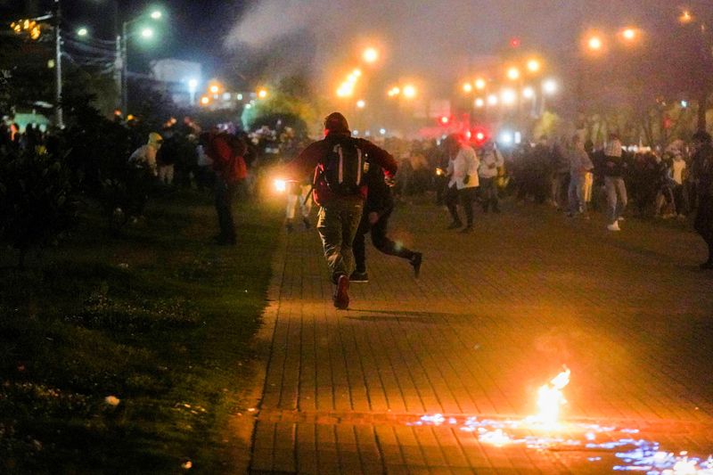 &copy; Reuters. Manifestantes corren mientras caen gases lacrimógenos durante una protesta que exige medidas gubernamentales para abordar la pobreza, la violencia policial y las desigualdades en los sistemas de salud y educación, en Bogotá, Colombia, 10 mayo 2021. REU