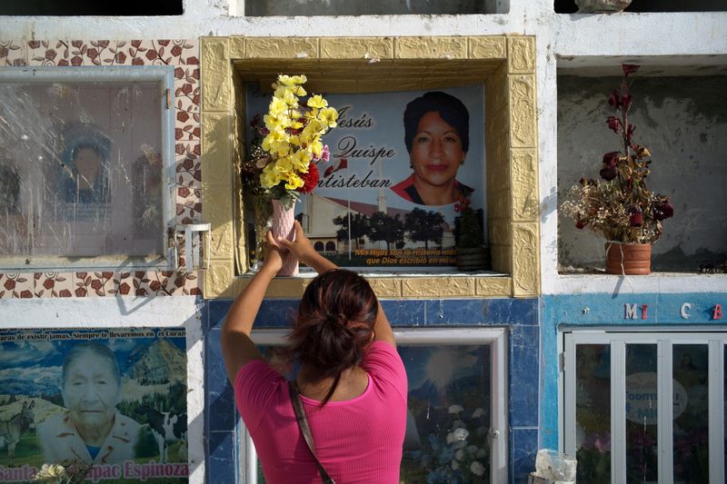 &copy; Reuters. Hellen Ñañez, que perdeu 13 familiares para a Covid, visita túmulo de tia em cemitério de Pisco, no Peru 
09/05/2021
REUTERS/Alessandro Cinque