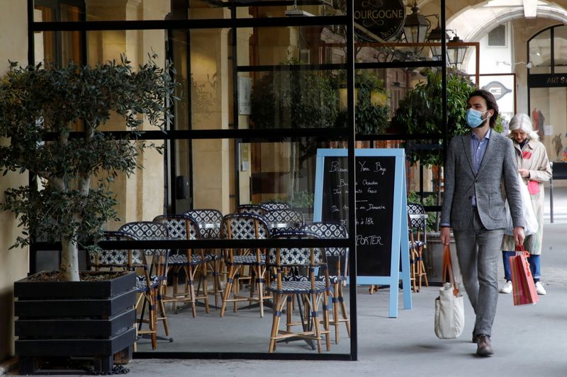 &copy; Reuters. FOTO DE ARCHIVO: Un hombre, usando una mascarilla, camina frente a un restaurante cerrado en medio del brote del coronavirus (COVID-19) durante la pandemia en Francia, 29 de abril del 2021. REUTERS/Sarah Meyssonnier/Foto de archivo