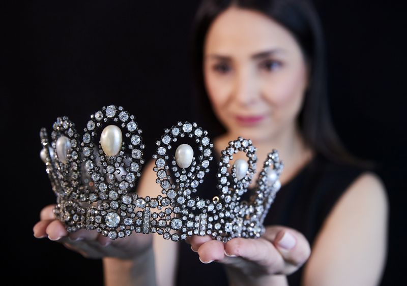 © Reuters. FILE PHOTO: A staff holds a diamond and pearl tiara passed down through generations of the Italian royal family during a preview at Sotheby's before their auction in Geneva, Switzerland, May 6, 2021.  REUTERS/Denis Balibouse