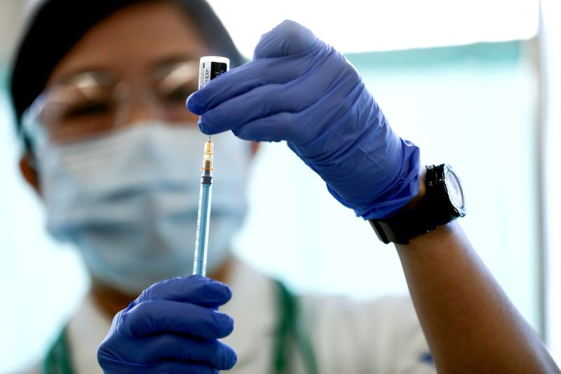 &copy; Reuters. FILE PHOTO: A medical worker fills a syringe with a dose of the Pfizer-BioNTech coronavirus disease (COVID-19) vaccine, at Tokyo Medical Center in Tokyo, Japan February 17, 2021. Behrouz Mehri/Pool via REUTERS/File Photo