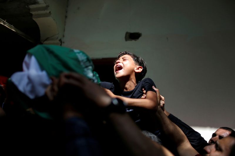 &copy; Reuters. El hermano del palestino Ahmed Al-Shenbari, que murió en enfretamientos, llora junto al cuerpo durante el funeral en el norte de la Franja de Gaza. 11 de mayo de  2021. REUTERS/Mohammed Salem     TPX IMAGES OF THE DAY