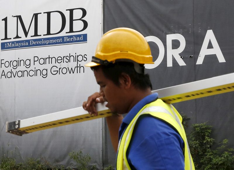 &copy; Reuters. A construction worker walks past a 1Malaysia Development Berhad (1MDB) billboard at the Tun Razak Exchange development in Kuala Lumpur, Malaysia