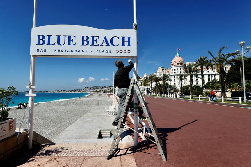&copy; Reuters. FILE PHOTO: A man uses a ladder during preparations for the reopenning of restaurants and beaches in Nice as part of an easing of the country's lockdown restrictions amid the coronavirus disease (COVID-19) outbreak in France, May 3, 2021.  REUTERS/Eric Ga