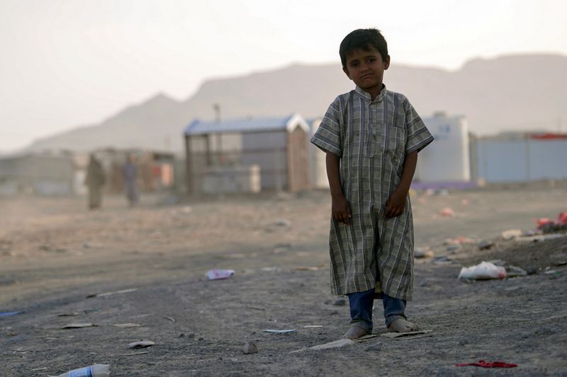 © Reuters. طفل يقف أمام مخيم للنازحين في مأرب يوم التاسع من مايو أيار 2021. تصوير: نبيل الأوزري - رويترز.