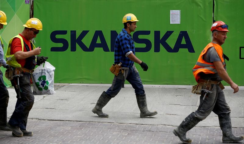 &copy; Reuters. FILE PHOTO: Workers walk past a Skanska logo seen on a fence at a construction site In Warsaw, Poland June 1, 2017. REUTERS/Kacper Pempel