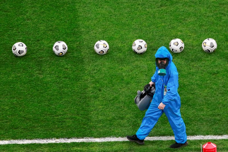 &copy; Reuters. A specialist wearing PPE (personal protective equipment), amid the coronavirus disease (COVID-19) outbreak, walks across the pitch before the match between Zenit Petersburg and Locomotiv Moscow at Gazprom Arena in Saint Petersburg, Russia May 2, 2021.  RE