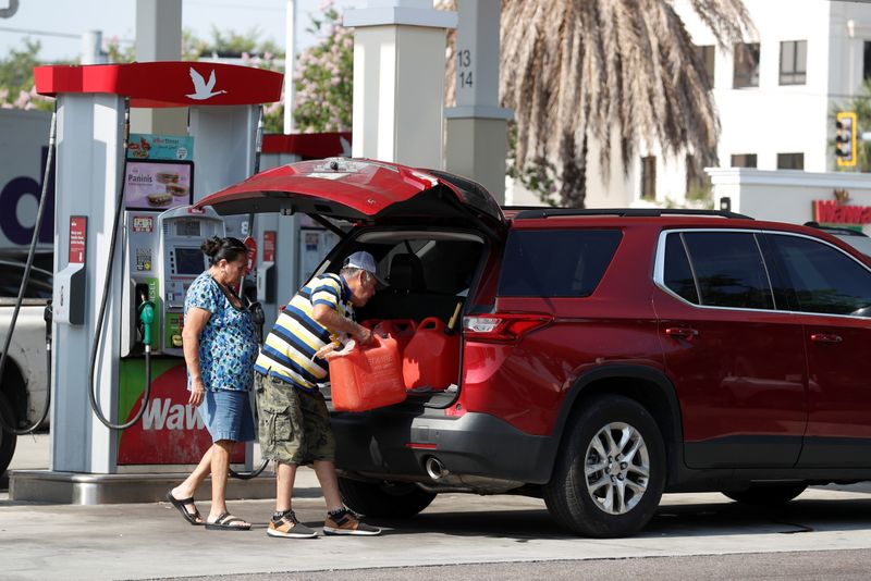 © Reuters. A man loads a 5 gallon gas tanks in his car after filling multiple of them up at a Wawa gas station, following a cyberattack that crippled the biggest fuel pipeline in the country, run by Colonial Pipeline, in Tampa, Florida, U.S., May 12, 2021. REUTERS/Octavio Jones